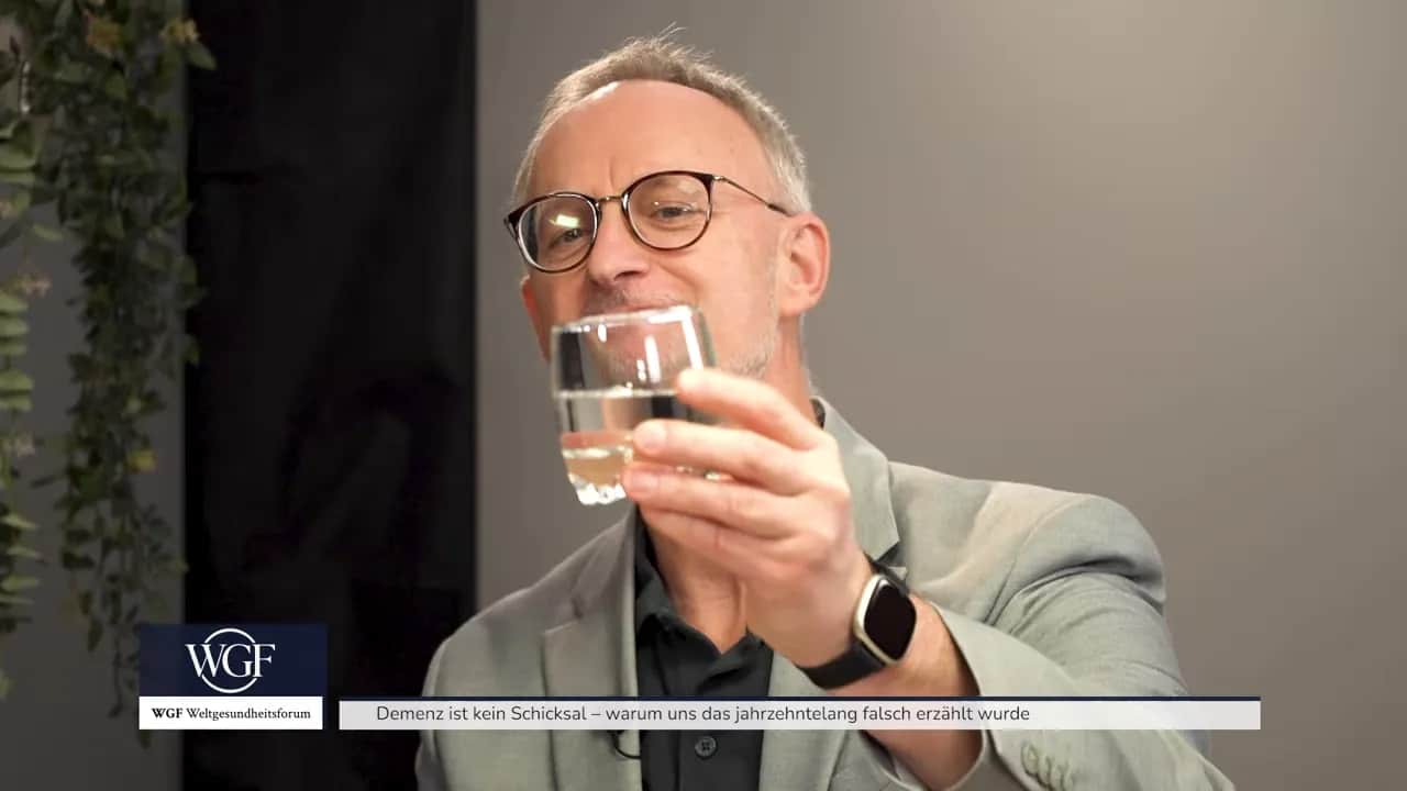 Demenz ist kein Schicksal – warum uns das jahrzehntelang falsch erzählt wurde 5 Alexander Glogg hält ein Glas in der Hand und erklärt etwas