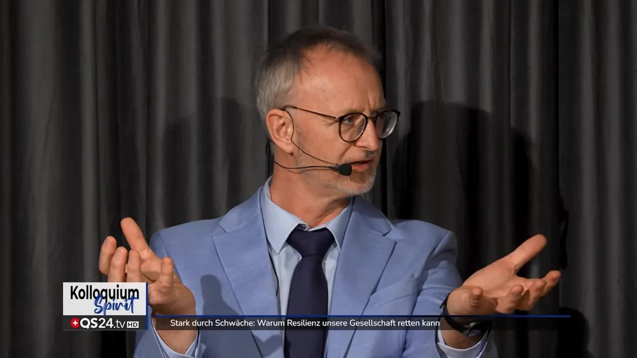 Stark durch Schwäche: Warum Resilienz unsere Gesellschaft retten kann 1 Moderator im hellblauen Sakko gestikuliert vor dunklem Vorhang